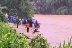 Lực lượng chức năng không quản nguy hiểm, tìm kiếm người bị mất tích. (Ảnh: TTXVN)