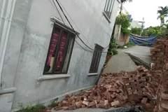 Phần móng một ngôi nhà bị sụt, nghiêng. (Ảnh: Mạnh Khánh/TTXVN)