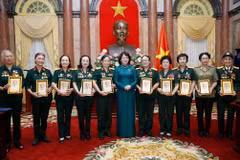 Phó Chủ tịch nước Đặng Thị Ngọc Thịnh tặng chân dung Chủ tịch Hồ Chí Minh cho các đại biểu nữ bộ đội Trường Sơn, thanh niên xung phong, dân quân hỏa tuyến, công nhân giao thông thời kỳ kháng chiến. (Ảnh: Lâm Khánh – TTXVN)