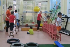 Giáo viên can thiệp, trị liệu và hỗ trợ hòa nhập cho trẻ ở Trung tâm. (Ảnh: Thùy Dung/TTXVN)