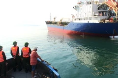 Tàu của Đồn Biên phòng cửa khẩu cảng Chân Mây tiếp cận tàu chở thuyền viên bị nạn. (Ảnh Hồ Cầu/TTXVN)