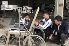 Hùng và Tân đang nghiên cứu thêm tính năng cho sản phẩm. (Ảnh: Hải Yến/TTXVN)