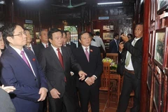 Các lãnh đạo Đảng và Nhà nước thăm nhà tưởng niệm đồng chí Hoàng Đình Giong ở xóm Nà Toàn, phường Đề Thám, thành phố Cao Bằng. (Ảnh: Quốc Đạt/TTXVN)