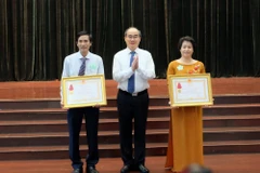 Bí thư Thành ủy Thành phố Hồ Chí Minh Nguyễn Thiện Nhân chúc mừng 2 tập thể có thành tích xuất sắc trong công tác giáo dục và đào tạo được nhận Huân chương Lao động hạng Ba. (Ảnh: Thu Hoài/TTXVN)
