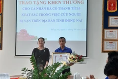 Sinh viên Nguyễn Hoàng Minh Vũ nhận khen thưởng đột xuất của UBND tỉnh Đồng Nai. (Ảnh: Lê Xuân/TTXVN)
