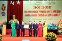 Thừa ủy quyền của Chủ tịch nước, Chủ tịch Ủy ban Nhân dân tỉnh Nam Định Phạm Đình Nghị trao Huân chương Độc lập hạng Nhất cho ngành Văn hóa tỉnh Nam Định. (Ảnh: Thái Thuần/TTXVN)