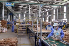 Công nhân làm việc tại dây chuyền chế biến gỗ công nghiệp thuộc Công ty cổ phần Woodsland Tuyên Quang. (Ảnh: Vũ Quang/TTXVN)