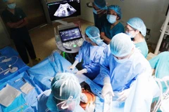 Các bác sỹ tiến hành phẫu thuật. (Ảnh: Đinh Hằng/TTXVN)
