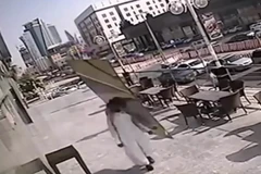 Tấm kính rơi ngay sát người đàn ông. (Nguồn: YouTube)