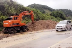Huy động máy xúc thu dọn đất sạt lở đảm bảo giao thông tren tuyến Quốc lộ 1A đoạn qua huyện Chi Lăng. (Ảnh: Thái Thuần/TTXVN)