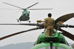 Một binh sỹ Lào theo dõi máy bay Mi-17 hạ cánh. (Nguồn: AFP)