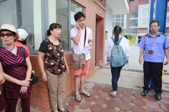 Em Dũng lo lắng vì gọi điện cho người thân không được. (Ảnh: Minh Sơn/Vietnam+)