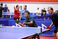 Các vận động viên thuộc Liên chi hội Nhà báo TTXVN tham gia nội dung đôi nam. (Ảnh: Minh Quyết/TTXVN)