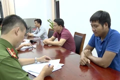 Lấy lời khai của nhóm đối tượng lừa đảo. (Ảnh: TTXVN phát)