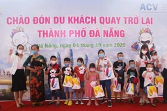 Tặng quà cho đoàn du khách đầu tiên trở lại du lịch thành phố sau dịch COVID-19. (Ảnh: Trần Lê Lâm/TTXVN)