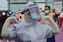 Nhân viên y tế hướng dẫn bệnh nhân COVID-19 tập thể dục tại Karawaci, tỉnh Banten, Indonesia, ngày 5/10/2020. (Ảnh: AFP/ TTXVN)