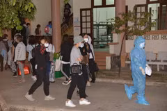Nhân viên y tế hướng dẫn công dân trở về vào khu vực cách ly tại Tiền Giang. (Ảnh: Nam Thái/TTXVN)