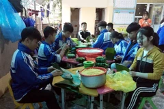 Các em Trường THPT Nguyễn Cảnh Chân, huyện Thanh Chương (Nghệ An) gói bánh chưng ủng hộ đồng bào lũ lụt các tỉnh miền Trung. (Ảnh: TTXVN phát)