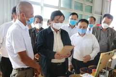 Bộ Trưởng Bộ Nông nghiệp và Phát triển nông thôn Lê Minh Hoan tham quan các gian hàng sản phẩm nông sản địa phương tại Gia Lai. (Ảnh: Hồng Điệp/TTXVN)