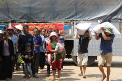 Cấp gạo cho các hộ khó khăn bị ảnh hưởng do hạn hán tại Đắk Lắk. (Ảnh: Dương Giang/TTXVN)