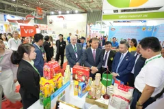 Thứ trưởng Đỗ Thắng Hải thăm quan các gian hàng tại Triển lãm. (Ảnh: PV/vietnam+)