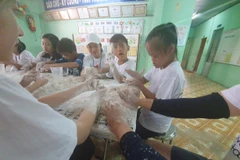 Các tình nguyện viên của Hansae Yes24 Foundation làm mô hình đất sét cùng các em học sinh tại Trường Nuôi dạy Trẻ Khuyết tật huyện Củ Chi. (Nguồn: Hansae cung cấp)