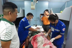 Các bác sỹ Trung tâm Cấp cứu 115, Bệnh viện Đa khoa tỉnh Khánh Hòa, kiểm tra sức khỏe của ngư dân gặp nạn trước khi khi đưa lên bờ. (Ảnh: Phan Sáu/TTXVN)