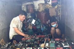 Lực lượng chức năng nghi vấn 412 bình ắcquy cũ là chất thải nguy hại, chưa qua xử lý. (Ảnh: TTXVN phát)