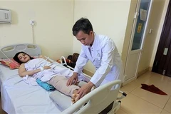 Bác sỹ Phan Văn Tú, Khoa Chấn thương Chỉnh hình, Bệnh viện Bà Rịa, thăm khám cho bệnh nhân T.T.N.Q sau ca phẫu thuật. (Ảnh: Hoàng Nhị/TTXVN)