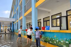 Giáo viên, nhân viên Trường Trung học cơ sở Nam Phương Tiến A dọn vệ sinh trường lớp sau nhiều ngày bị ngập sâu. (Ảnh: Nguyễn Cúc/TTXVN)
