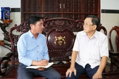 Đảng viên Đoàn Văn Thơ (bên phải), nguyên Bí thư Huyện ủy Tân Phú Đông, tỉnh Tiền Giang, hiện sinh hoạt tại chi bộ phường Long Hòa, thành phố Gò Công, tỉnh Tiền Giang trao đổi với tác giả: (Ảnh: Hữu Chí/TTXVN)