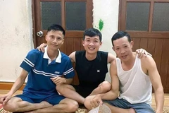 Anh Trần Văn Ninh, người bị đuối nước (ngồi giữa) hai anh Vinh (bên phải) và anh Cường (bên trái). (Ảnh: TTXVN phát)