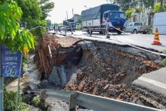 Tình trạng sạt lở bờ sông ảnh hưởng đến mặt đường nhựa Quốc lộ 80. (Ảnh: TTXVN phát)