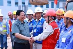 Thủ tướng Phạm Minh Chính với công nhân thi công dự án. (Ảnh: Dương Giang/TTXVN)