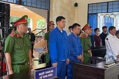 Bị cáo Lê Dương (áo xanh bên trái) và bị cáo Hoàng Văn Tính (áo xanh bên phải) trước tòa. (Ảnh: Sỹ Tuyên/TTXVN)