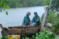 Trời mưa cộng thêm nước sông lên cao khiến việc tìm kiếm, trục vớt tài sản gặp không ít khó khăn. (Ảnh: Thanh Liêm/TTXVN)