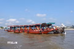 Hai du khách người Mỹ thưởng thức bữa sáng trên ghe ở Chợ nổi Cái Răng. (Ảnh: Thanh Liêm/TTXVN)