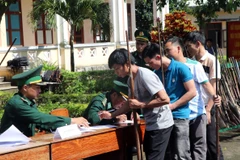 Người dân tự nguyện giao nộp vũ khí tại đồn Biên phòng Ia Đal, tỉnh Kon Tum. (Ảnh: Cao Nguyên/TTXVN)