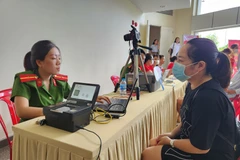 Công an tỉnh Thừa Thiên-Huế hỗ trợ người nhà bệnh nhân tại Bệnh viện Trung ương Huế thông báo lưu trú qua phần mềm ASM. (Ảnh: Mai Trang/TTXVN)