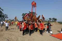 Những cỗ kiệu được rước ra bãi cát, nơi tương truyền Chử Đồng Tử và Tiên Dung Công chúa gặp nhau. (Ảnh: Trấn Việt/TTXVN) 