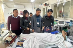 Chủ tịch Công đoàn ngành Giáo dục Hà Nội Đỗ Văn Nam tặng quà cho em Đ.T.M. (Ảnh: TTXVN phát)