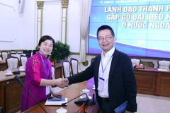 Cái bắt tay nhất trí góp sức phụng sự quê hương giữa bà Trần Tuệ Tri, kiều bào Singapore (bên trái) và ông Lâm Việt Tùng, kiều bào tại Hà Lan. (Ảnh: Xuân Khu/TTXVN)