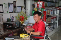Ông Nguyễn Văn Quởn làm việc tại cửa hàng của mình. (Ảnh: Minh Trí/TTXVN)