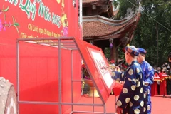 Nhà thư pháp Nguyễn Đình Kế, Câu lạc bộ thư pháp Hán Nôm tỉnh Hải Dương đã trình diễn khai bút Hán văn với chủ đề Quốc thái dân an. (Ảnh: Mạnh Minh/TTXVN)