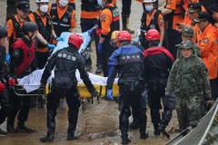 Lực lượng cứu hộ di chuyển nạn nhân vụ ngập lụt. (Nguồn: Reuters) 