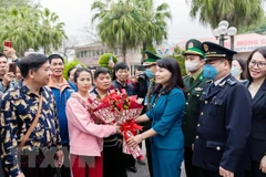 Lãnh đạo thành phố Móng Cái tặng hoa chúc mừng các đoàn khách quốc tế đầu tiên qua cửa khẩu quốc tế Móng Cái. (Ảnh: TTXVN phát)