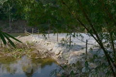 Các khu dã ngoại đổ bêtông, cát sỏi nhằm san nền, xây dựng khu lưu trú ngay sát bờ sông Luông Đông. (Ảnh: Quốc Dũng/TTXVN) 