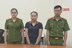 Bị can Vì Thị Thảo (giữa) bị bắt tạm giam. (Ảnh: TTXVN phát)