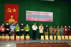 Trưởng Ban Tuyên giáo Trung ương Nguyễn Trọng Nghĩa trao quà cho hộ nghèo và công nhân lao động có hoàn cảnh khó khăn ở tỉnh Đồng Tháp. (Ảnh: Nhựt An/TTXVN)