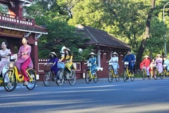 Đạp xe tuần hành hưởng ứng Tuần lễ Áo dài cộng đồng Huế 2023. (Ảnh: Mai Trang/TTXVN)